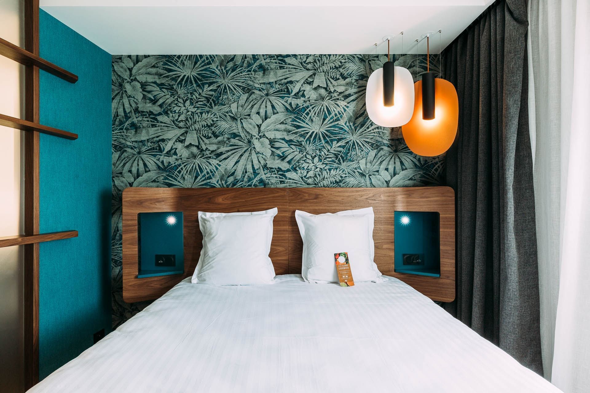 Lit king-size et luminaires dans une chambre à l'Oceania Paris Porte de Versailles