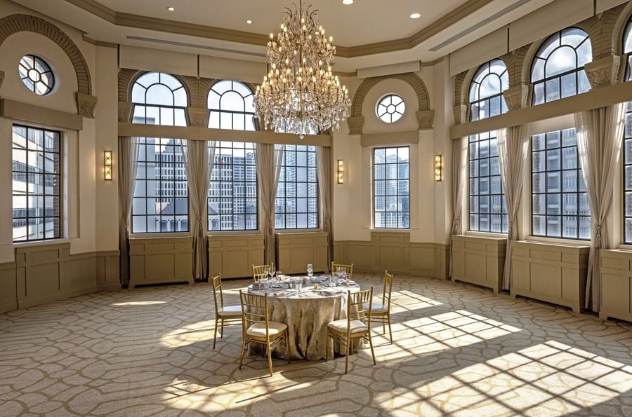 Huron Room with a setup banquet table near large windows under a grand chandelier at Warwick Allerton Chicago