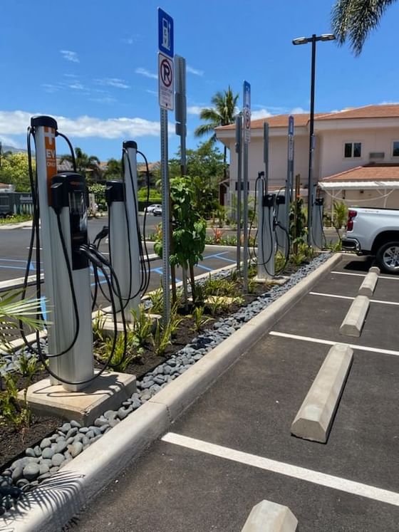 A row of electric charging stations in a parking lot at Maui Coast Hotel