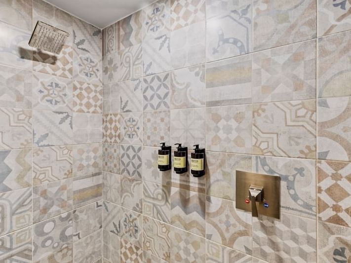 Ducha con tres botellas de productos de baño en la Junior Suite con terraza y cama King en Fiesta Americana Hacienda Ixtapan de la Sal, Estado de México.