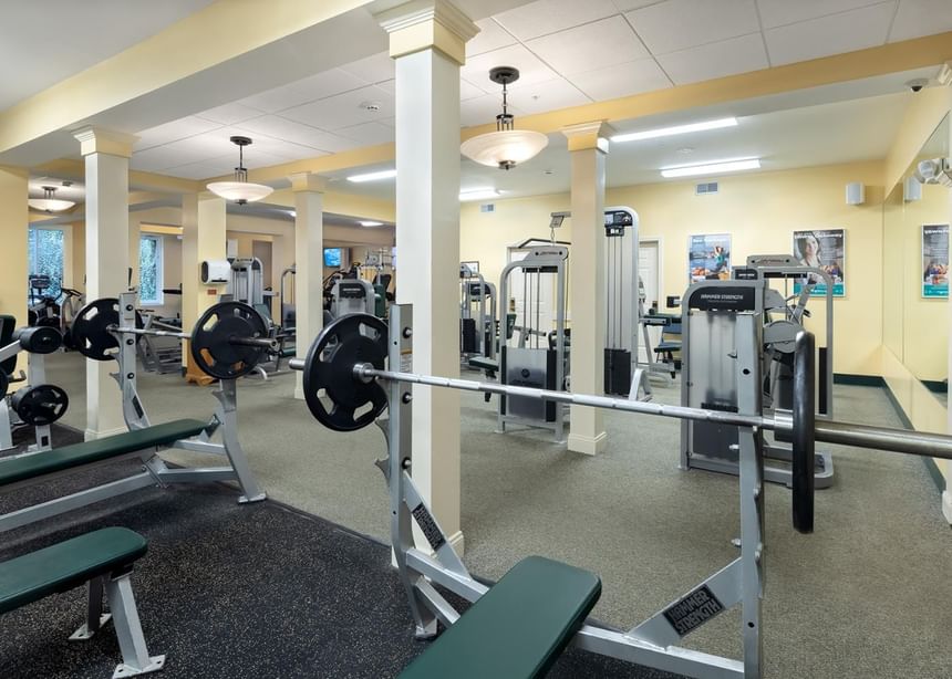 Benches with built-in bar racks & various fitness training equipment in Ogunquit Fitness Center at Meadowmere Resort