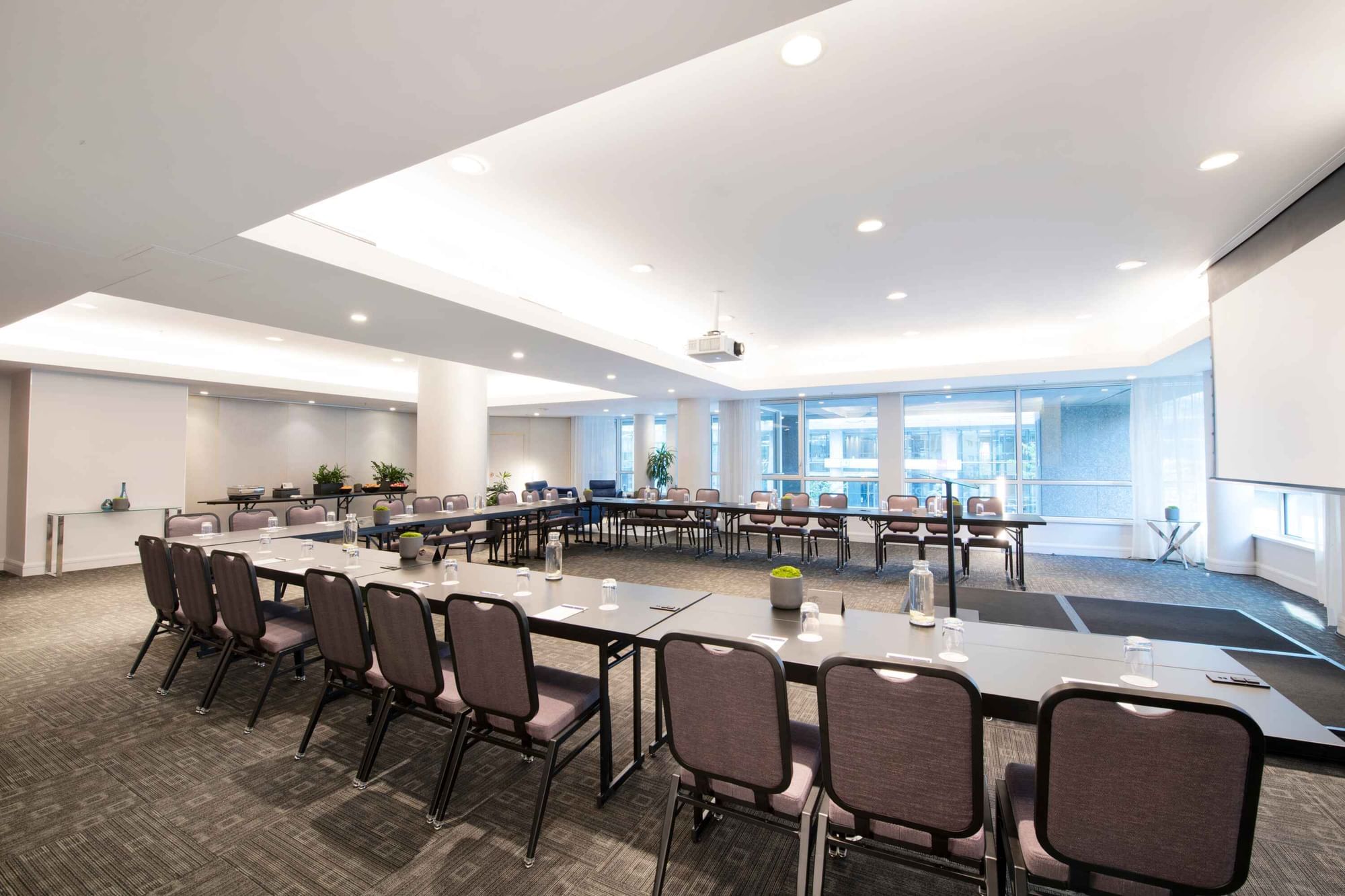 U-shaped table set-up with a projector screen in Salon Crescent at Warwick Hotels and Resorts