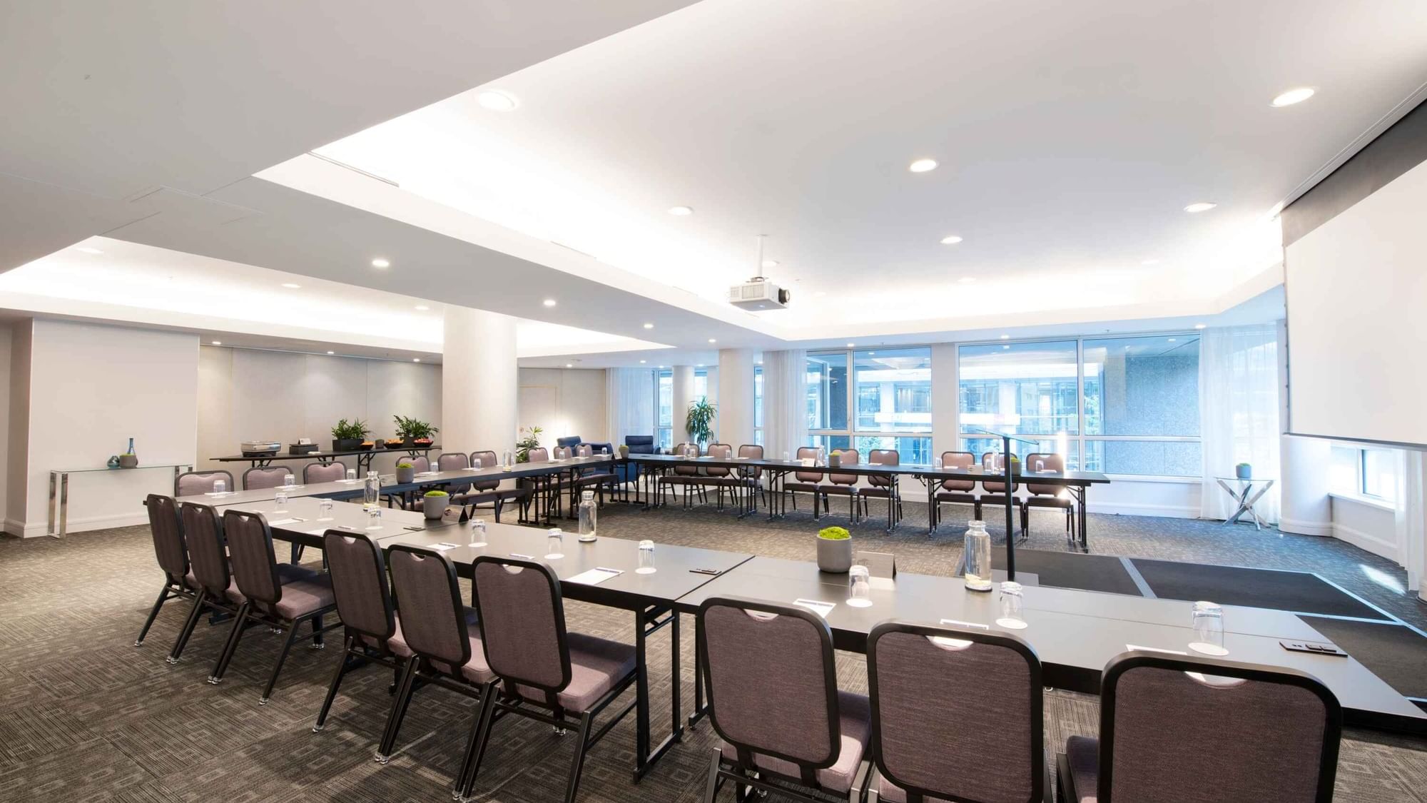 U-shaped table set-up with a projector screen in Salon Crescent at Warwick Hotels and Resorts