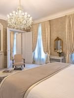 Elegant bedroom with chandelier and Rue de la Paix view at Hôtel Westminster in Paris.