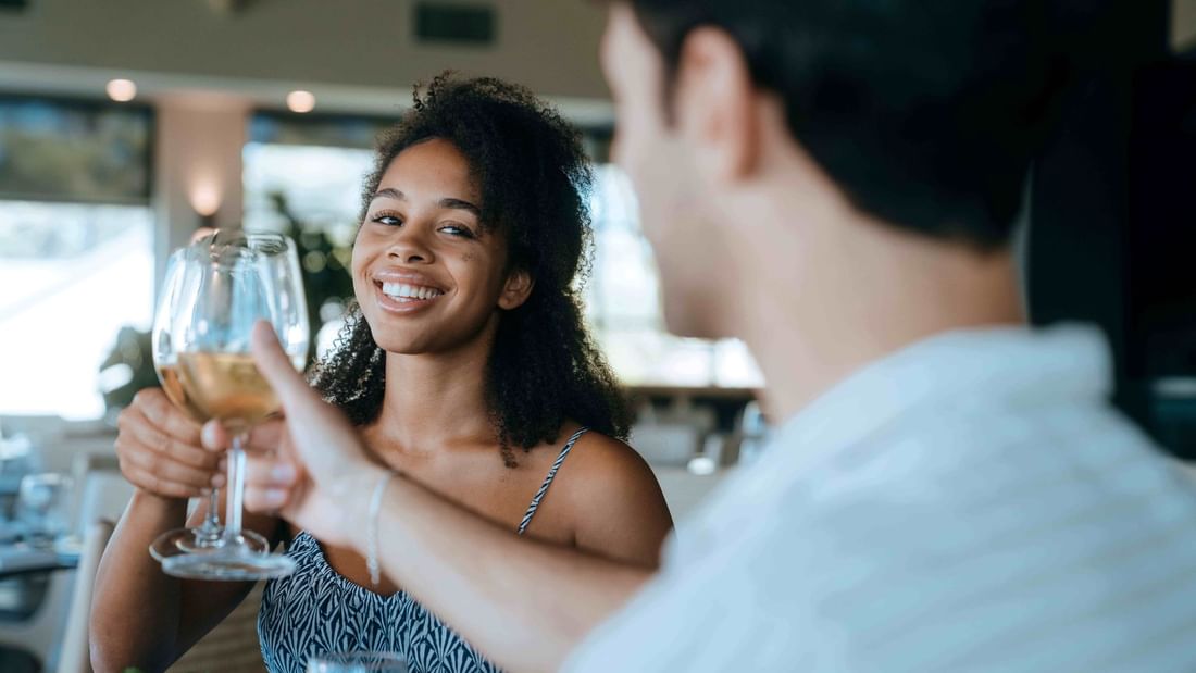 Couple toasting white wine while dining in The Cellar Kitchen Bar at Novotel Barossa Valley Resort