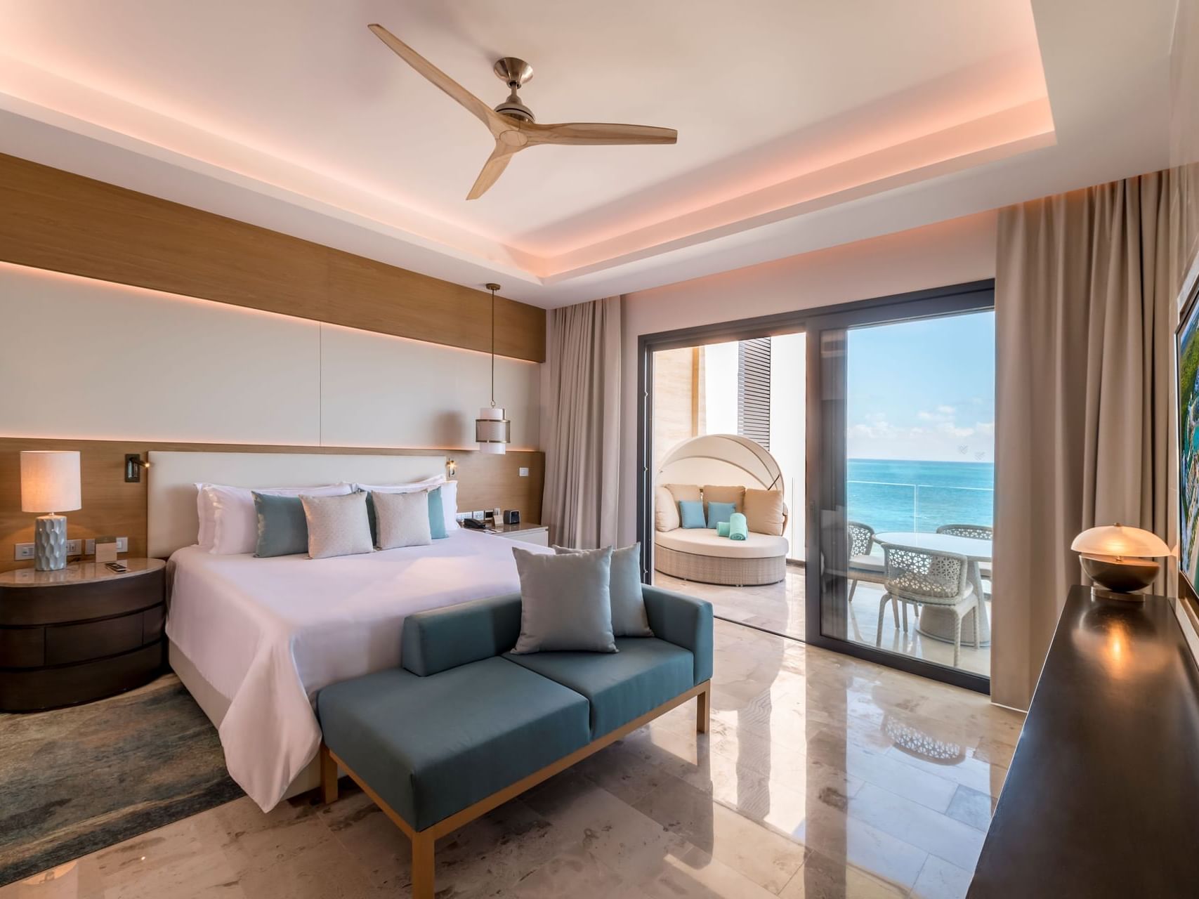 King bed with comfy pillows & balcony of Junior Suite Ocean Front View at Heaven Resort