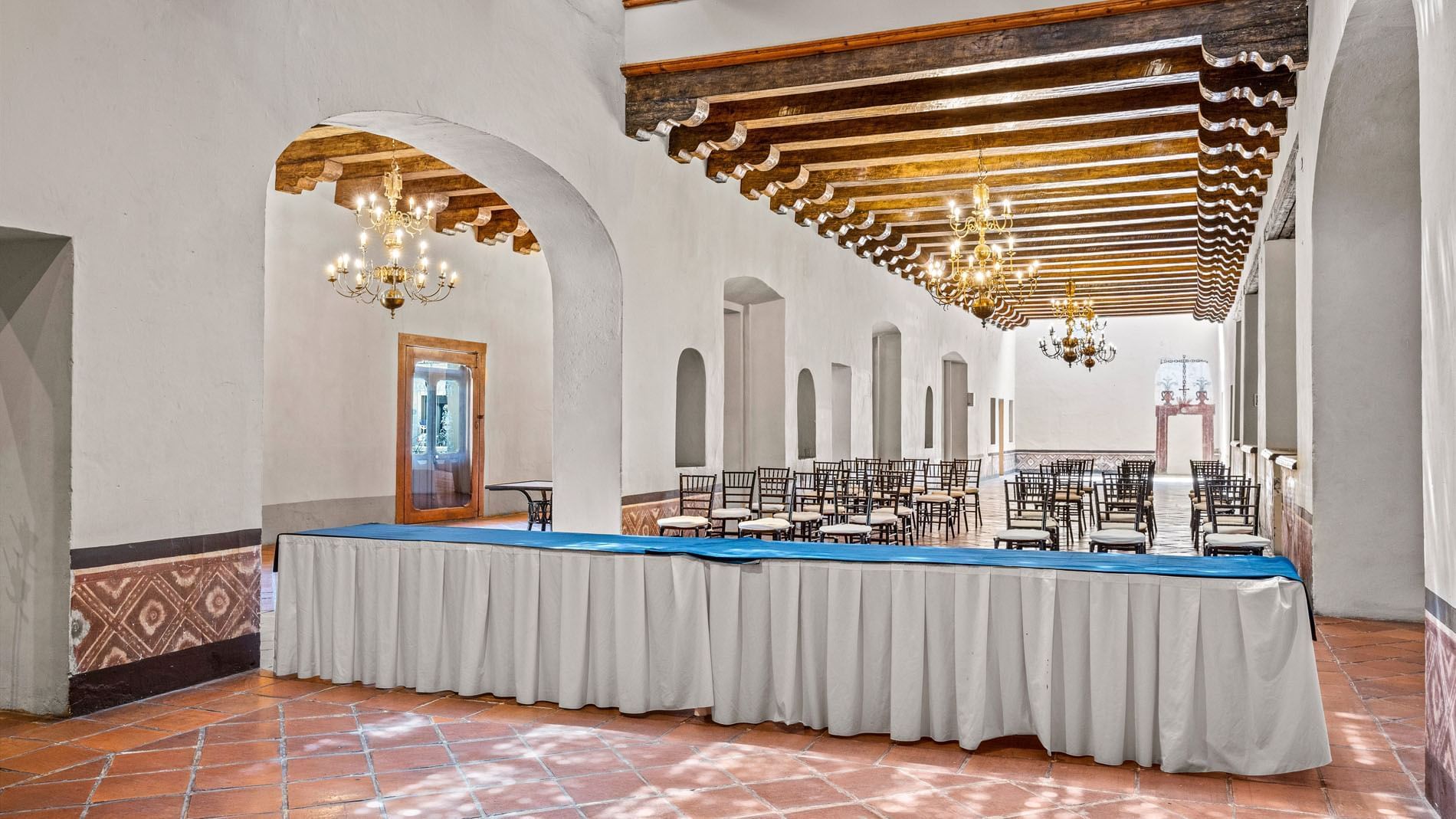 La Concepción event hall with terracotta tiles, wood-beamed ceilings, and gold chandeliers at Quinta Real Puebla