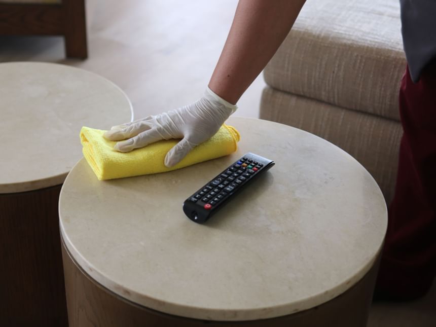 Staff cleaning a table top in a Room at Hotel Coral y Marina