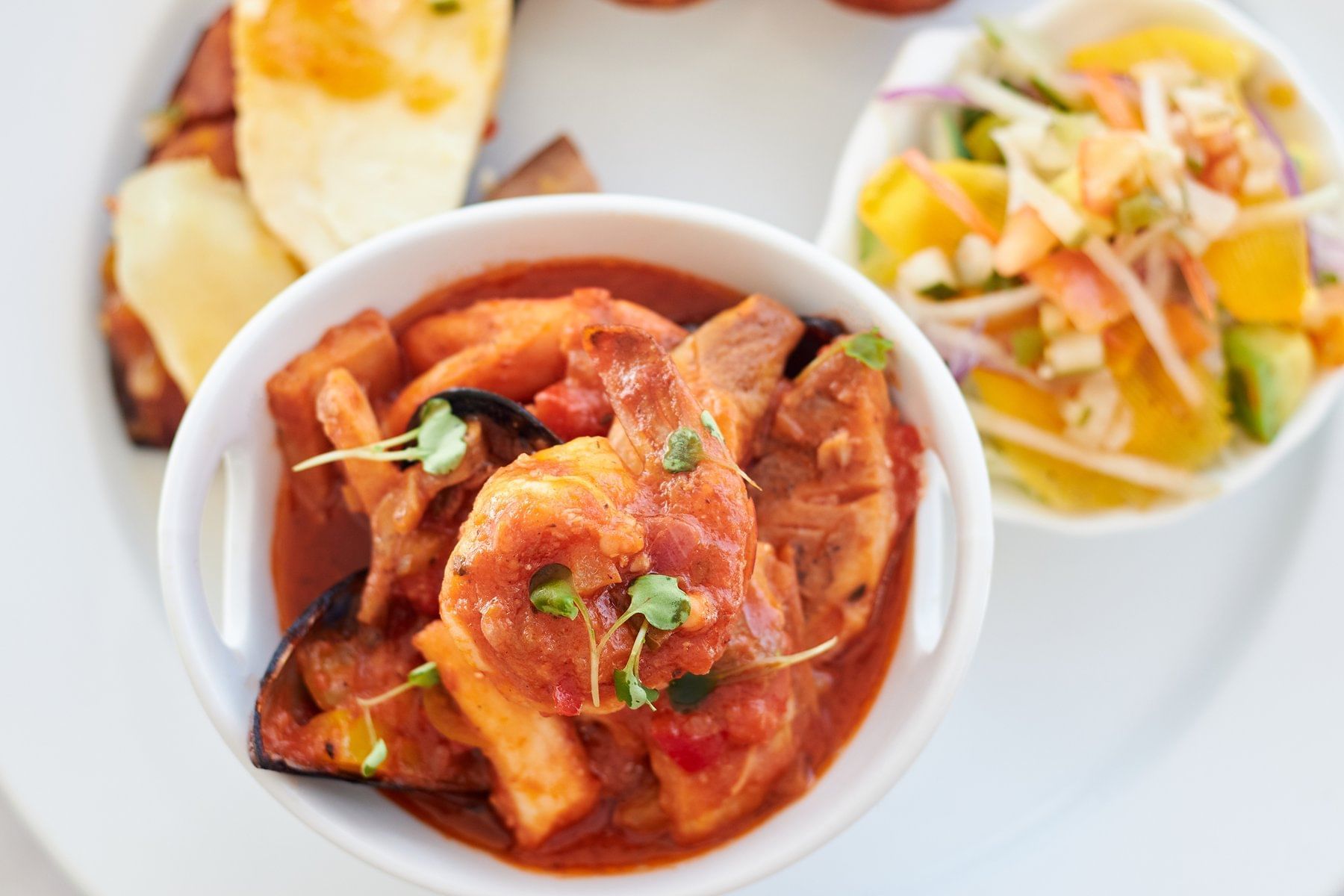 Bowl of seafood stew with shrimp, mussels, and vegetables in a tomato sauce served in Hi Tide Restaurant at Bay Gardens Inn