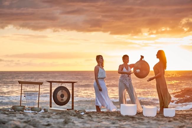 Evening sound healing at Cala Luna Boutique Hotel, featuring gongs and crystal bowls against a sunset sky