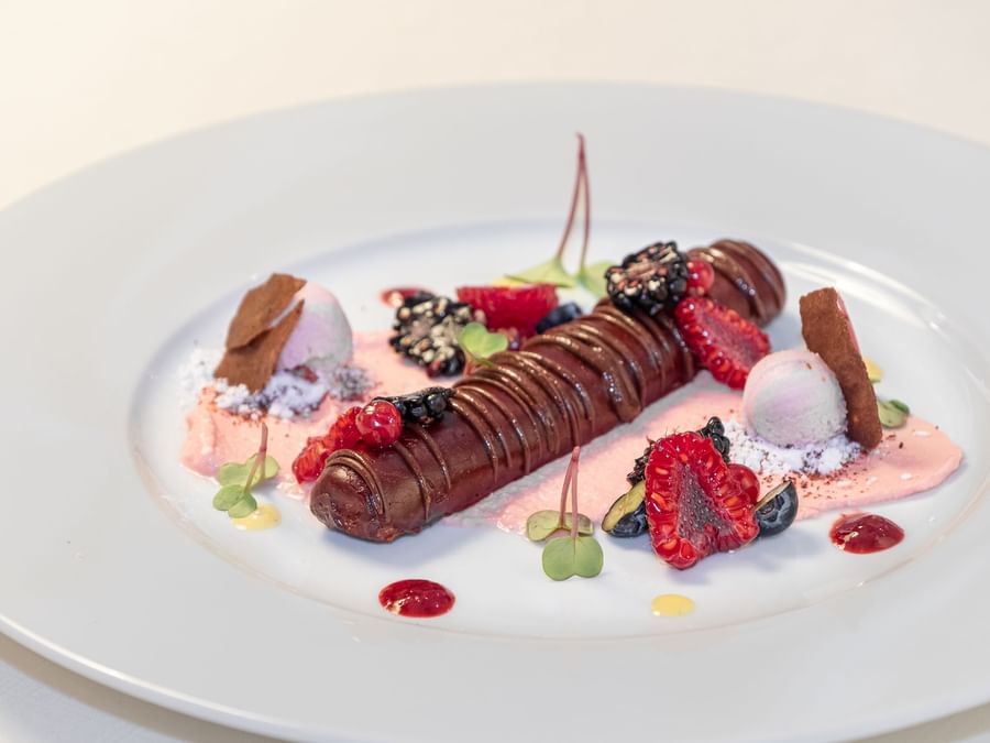 A chocolate dessert with raspberries at The Originals Hotels