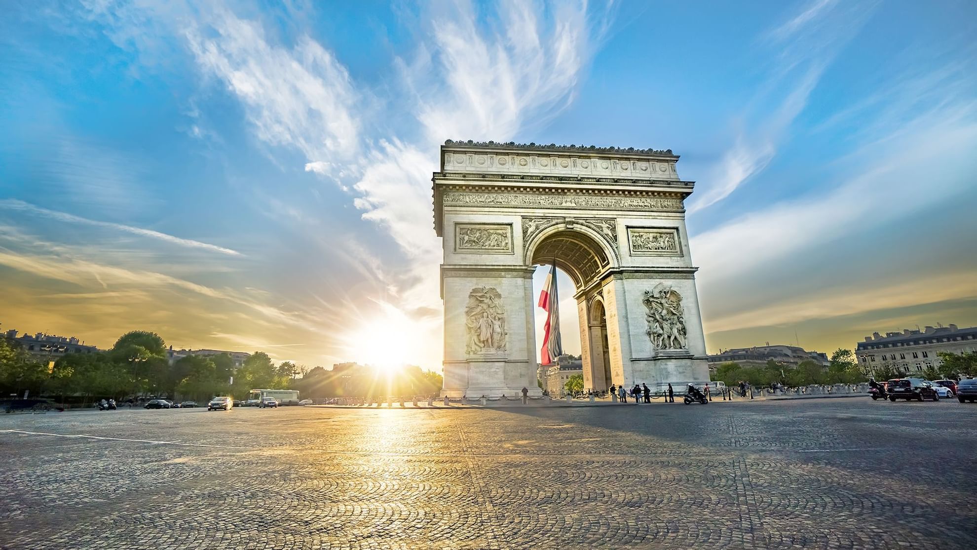 The Arc de Triomphe stands majestically as the sun sets behind it, featuring locations near Warwick Hotels and Resorts