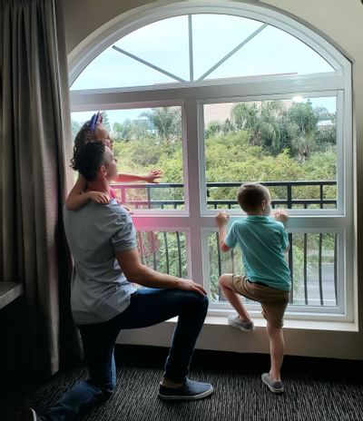 A family looking outside from Grand Legacy at The Park Anaheim.