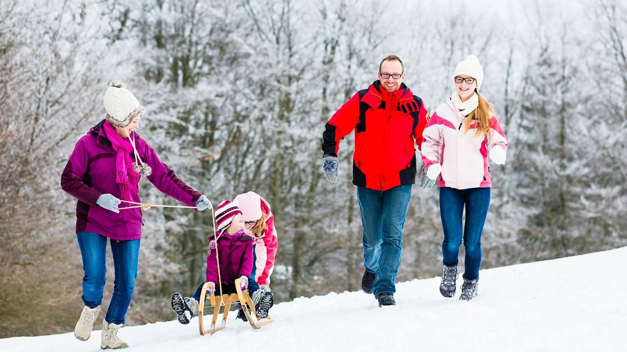 A family having fun in a snowy setting with a sled