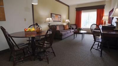 living room area with table, sofa, desk and window