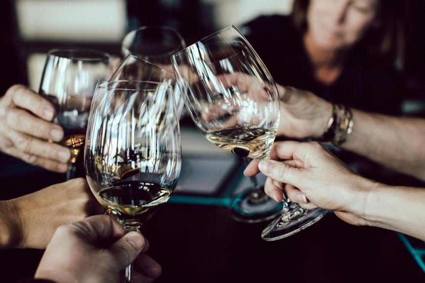 Group toasting wine glasses in Regent Restaurant & Bar at Hotel Brookmere