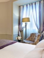Bed with a couch by the open door to the bathroom in the Executive Room at Hotel Westminster Paris