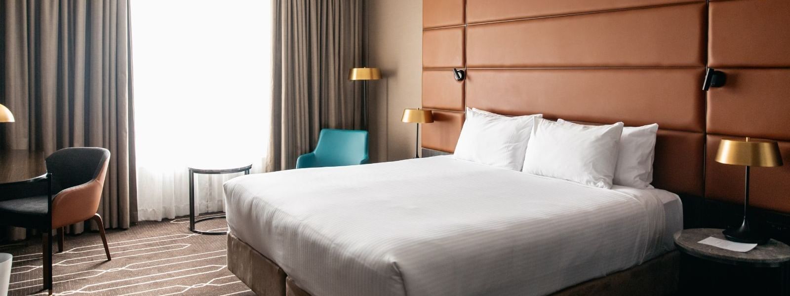 Comfortable hotel room with a large bed, modern decor, and elegant furniture showcasing The Comfort Combo.