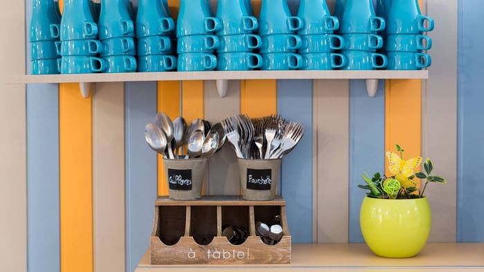 Wooden cutlery holder & mugs in the kitchen at Hotel clermont 