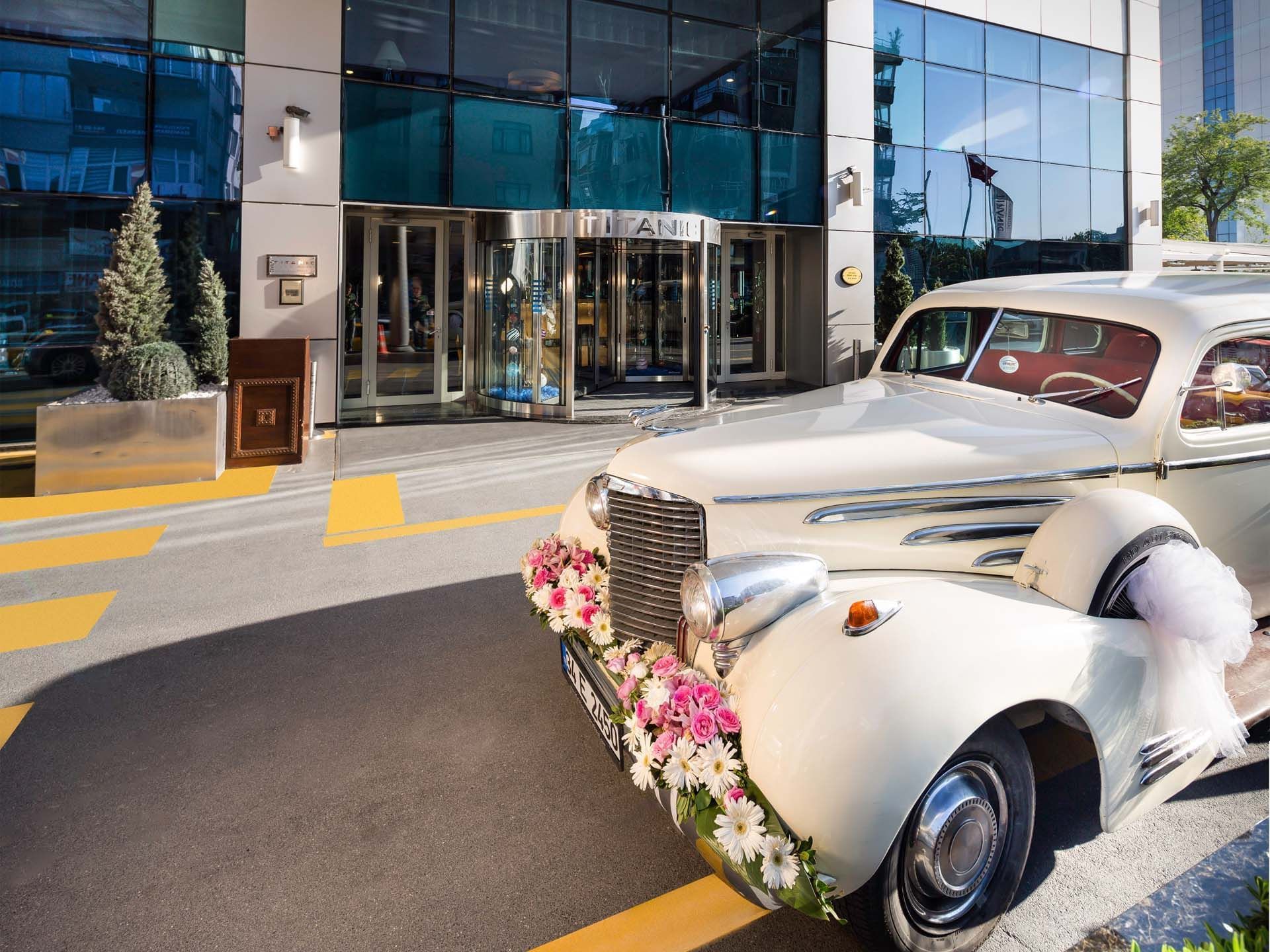 Titanic Port Bakırköy girişinde, zarif çiçeklerle süslenmiş beyaz vintage araç eşliğinde unutulmaz anılar biriktirin; nostaljik dokunuşlarla karşılanmanın keyfini yaşayın.