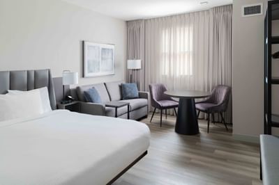 Sitting area by the bed in a cozy room with wooden floors at Portland Harbor Hotel