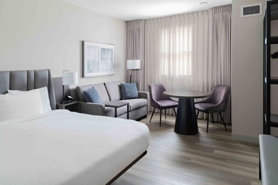 Sitting area by the bed in a cozy room with wooden floors at Portland Harbor Hotel