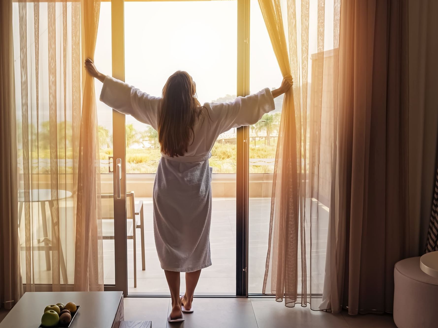 Girl opening curtains in a room at Daydream Island Resort