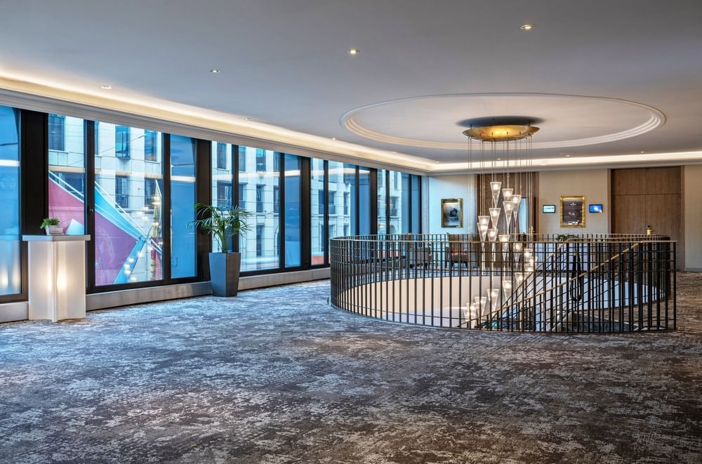 Espace événementiel moderne avec grandes baies vitrées et lustre design au Warwick Geneva Genève