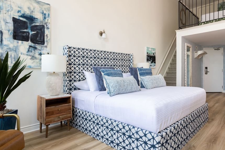 Comfy bed, nightstand & stairway in Superior Loft at Retro Suites Hotel