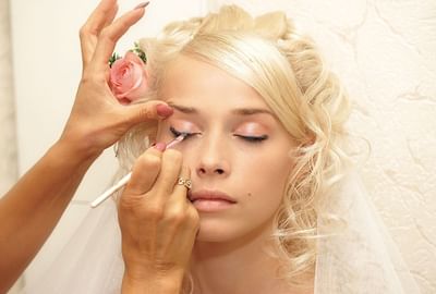 Bride receiving makeup treatment.