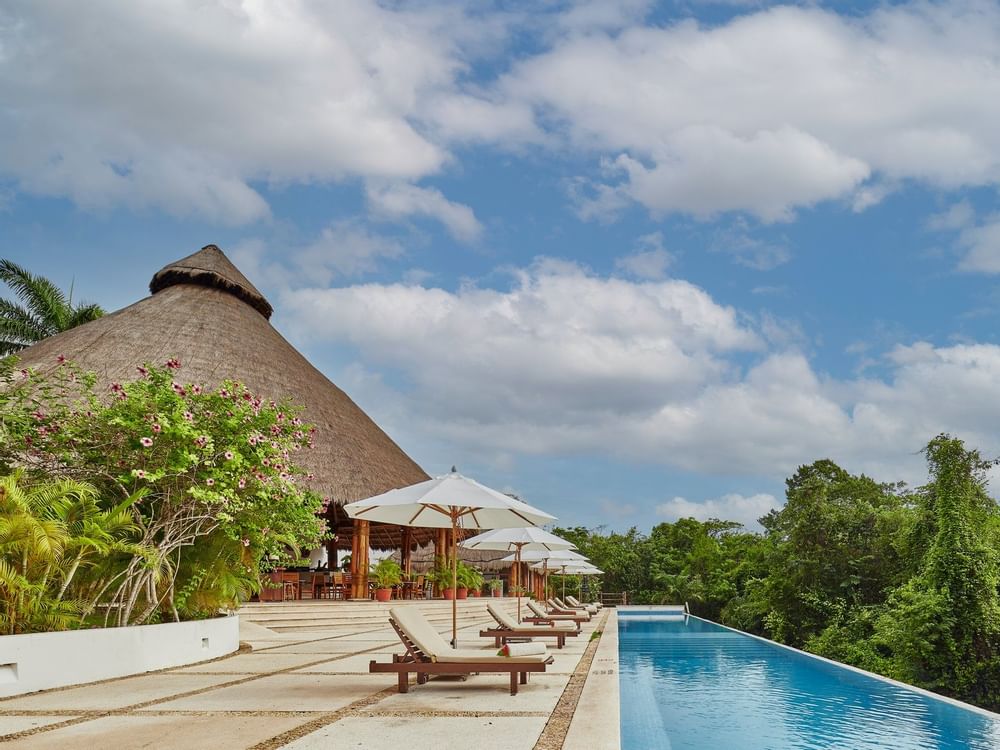 Outdoor pool with sun loungers at The Explorean Kohunlich