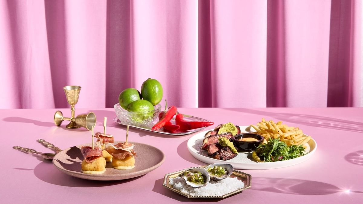 Dining set up with various dishes on a pink table in Fidels Restaurant at Crown Hotel Melbourne