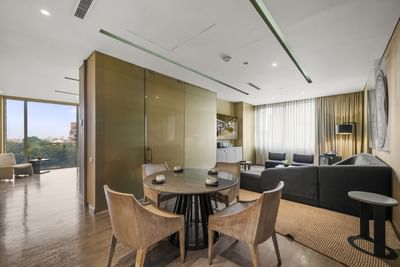 Sala de estar moderna con sofá, mesa de centro, mesa de comedor redonda y sillas.