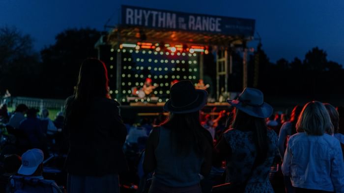 Crowd watching Rhythm on the Range event with performers on stage at night.