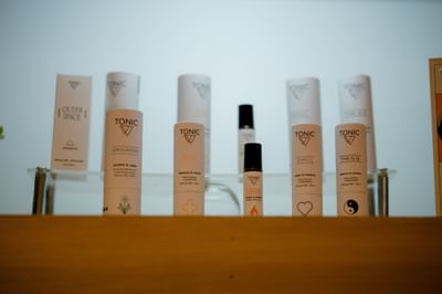 Tonic brand natural skincare products and essential oil bottles on a wooden shelf at La Tourelle Hotel and Spa