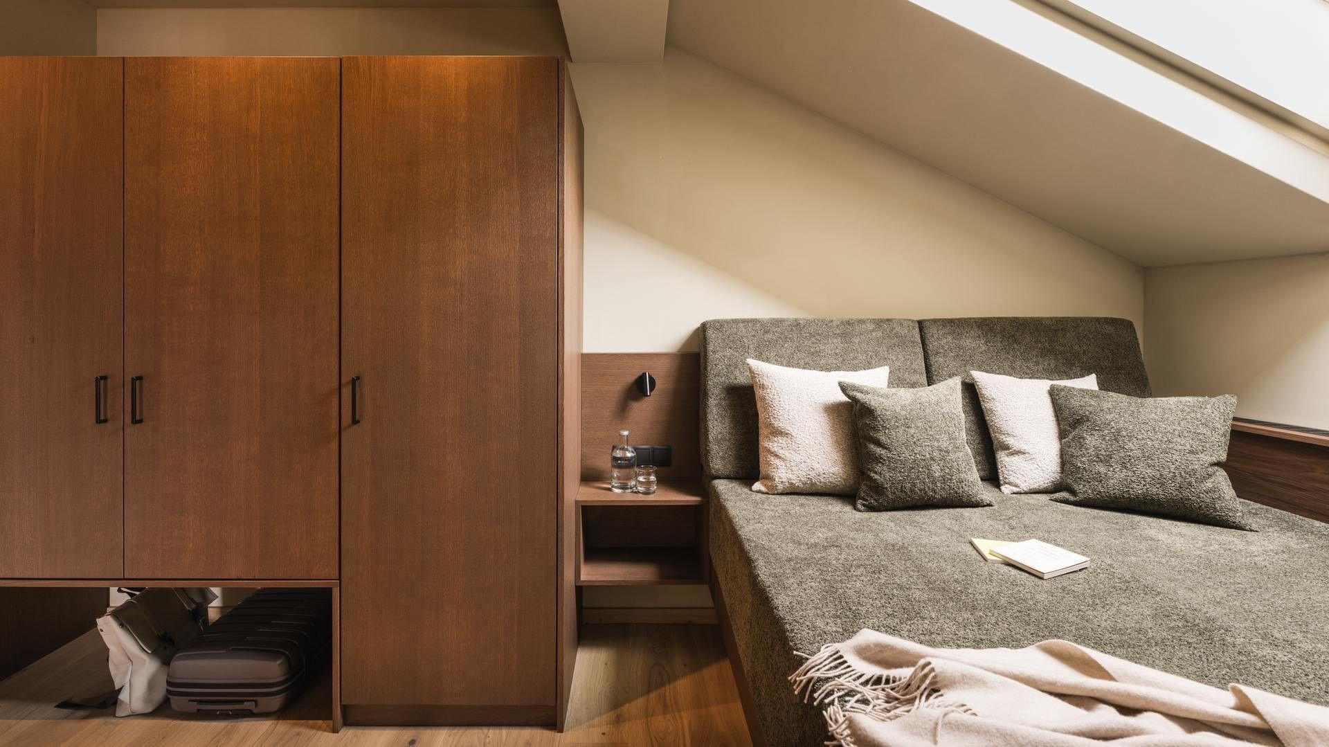 Geräumige Premium Suite Bergliebe mit Bett und Schrank im Falkensteiner Hotel Antholz.