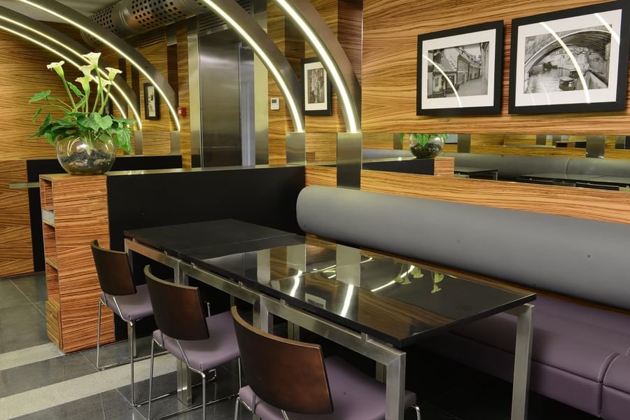 Black tables by purple chairs under arched light beams in O'cocco Restaurant at Warwick Stone 55 - Beirut
