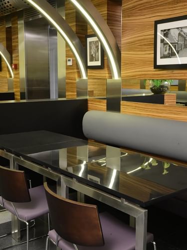 Black tables by purple chairs under arched light beams in O'cocco Restaurant at Warwick Stone 55 - Beirut