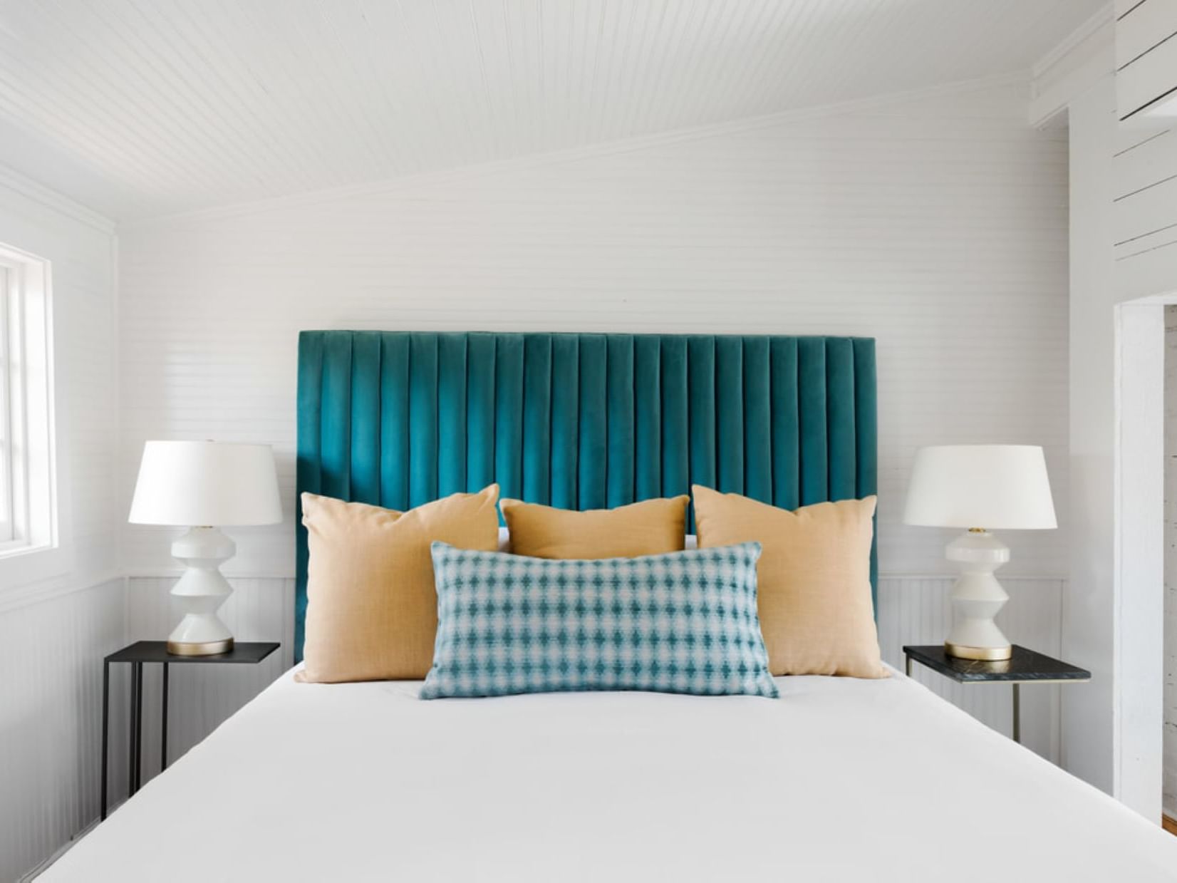 Cozy bed with a blue headboard and nightstand in Cismont Room at The Clifton