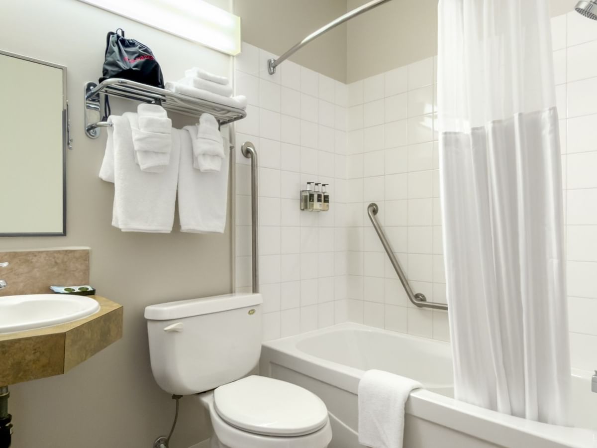 Accessible bathroom at Coast Innisfail Hotel with bathtub, toilet and sink