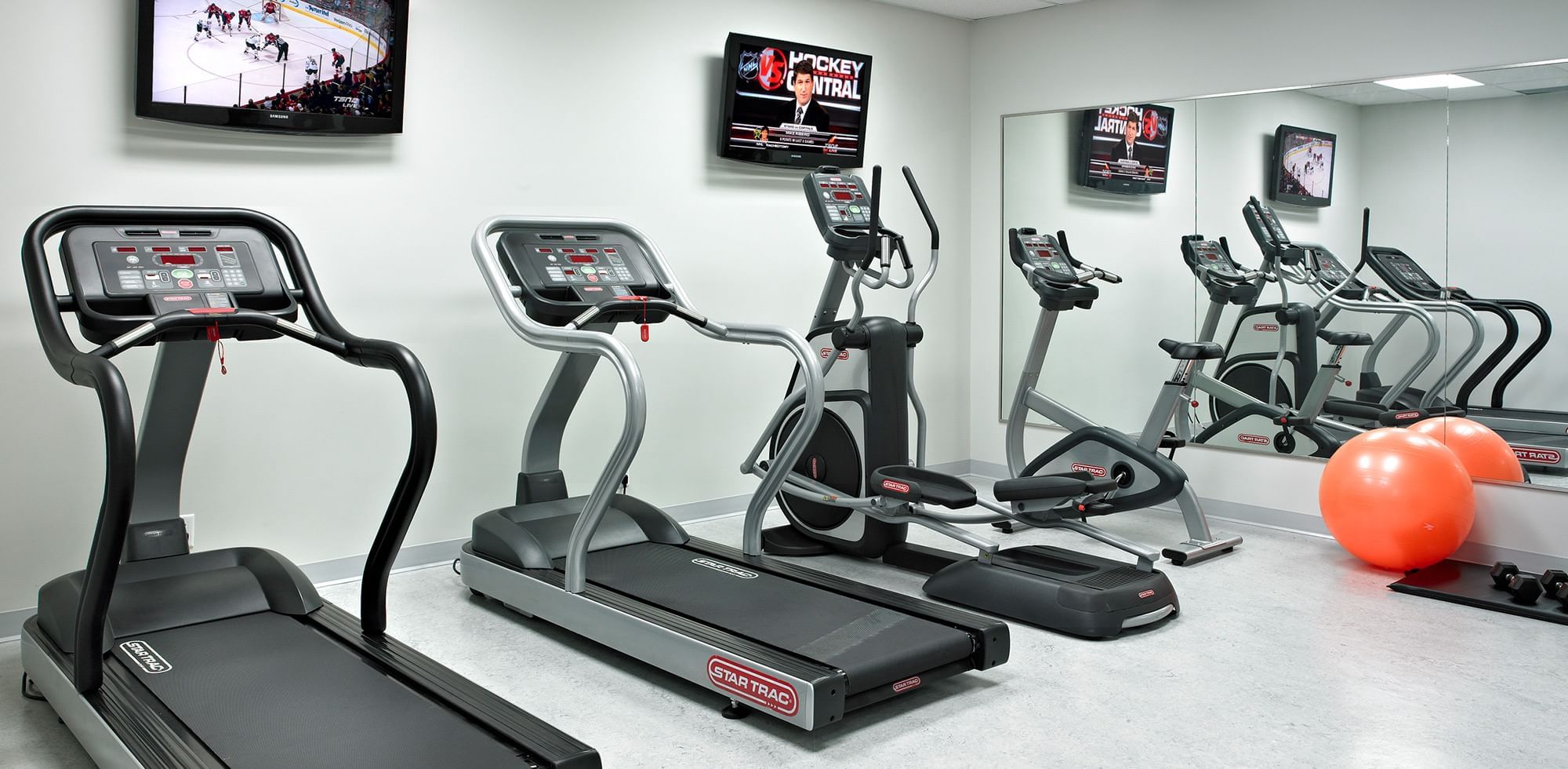fitness room with treadmills, TVs and exercise ball
