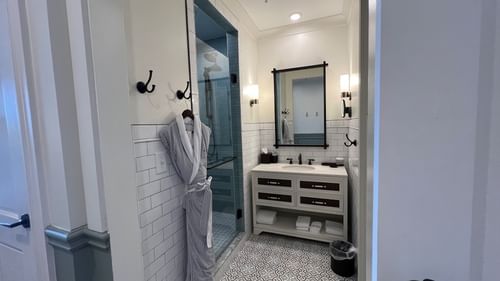 Bathroom vanity & shower area in Pine Suite with a bathrobe at Camp Creek Inn