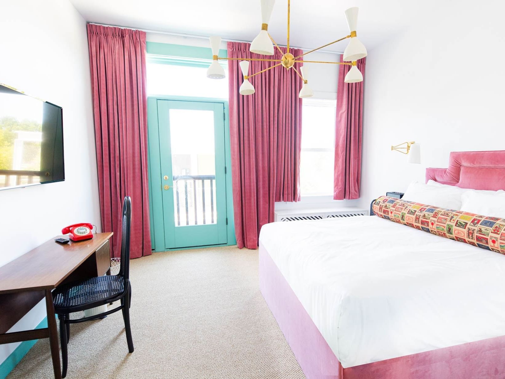 bed with pink bed frame in white room with pink curtains