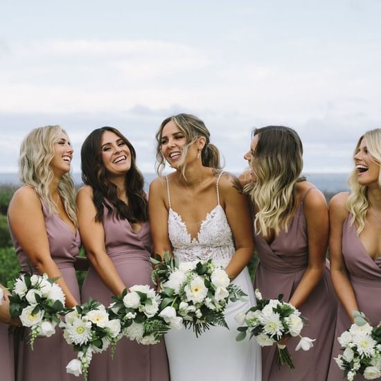 Bride taking photos with brides mates in the garden at Pullman Magenta Shores