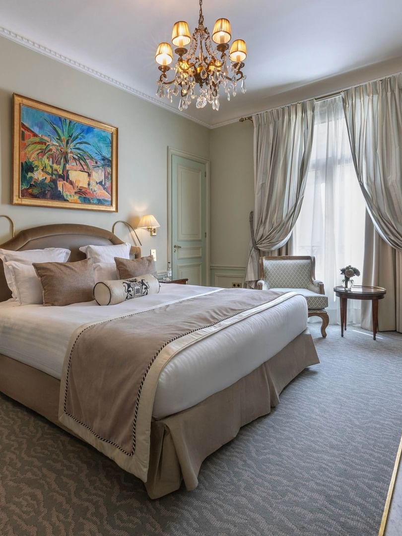 Deluxe Suite Parisienne room with large bed and chandelier at Hôtel Westminster - Paris.