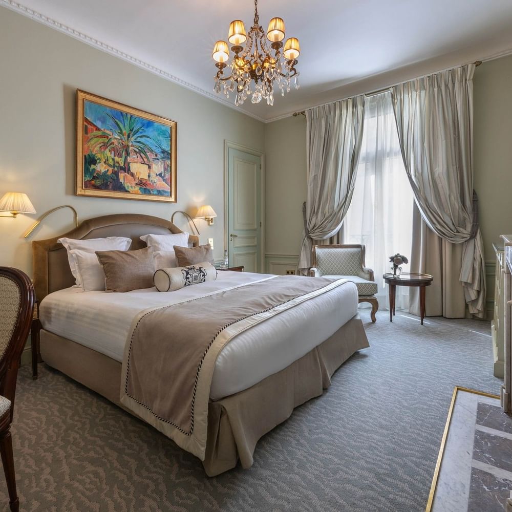 Deluxe Suite Parisienne room with large bed and chandelier at Hôtel Westminster - Paris.