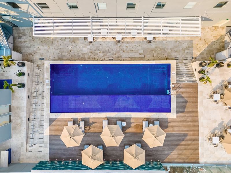 Ariel view of outdoor pool area with sunbeds at One Hotels