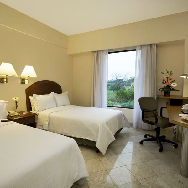 Twin beds with working desk in Superior Room at Fiesta Inn