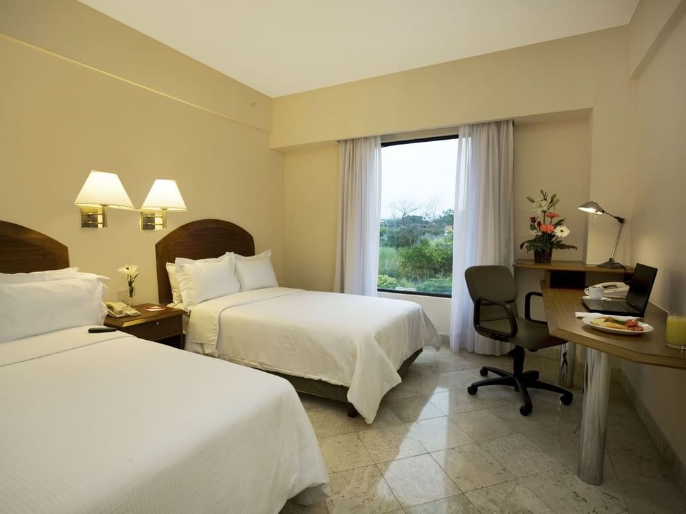 Twin beds with working desk in Superior Room at Fiesta Inn