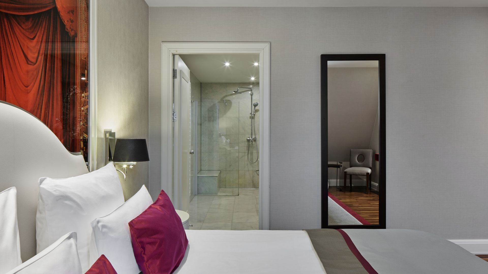 Schlafzimmer mit angeschlossenem Badezimmer und Spiegel in der Titanic Suite im Titanic Gendarmenmarkt Berlin